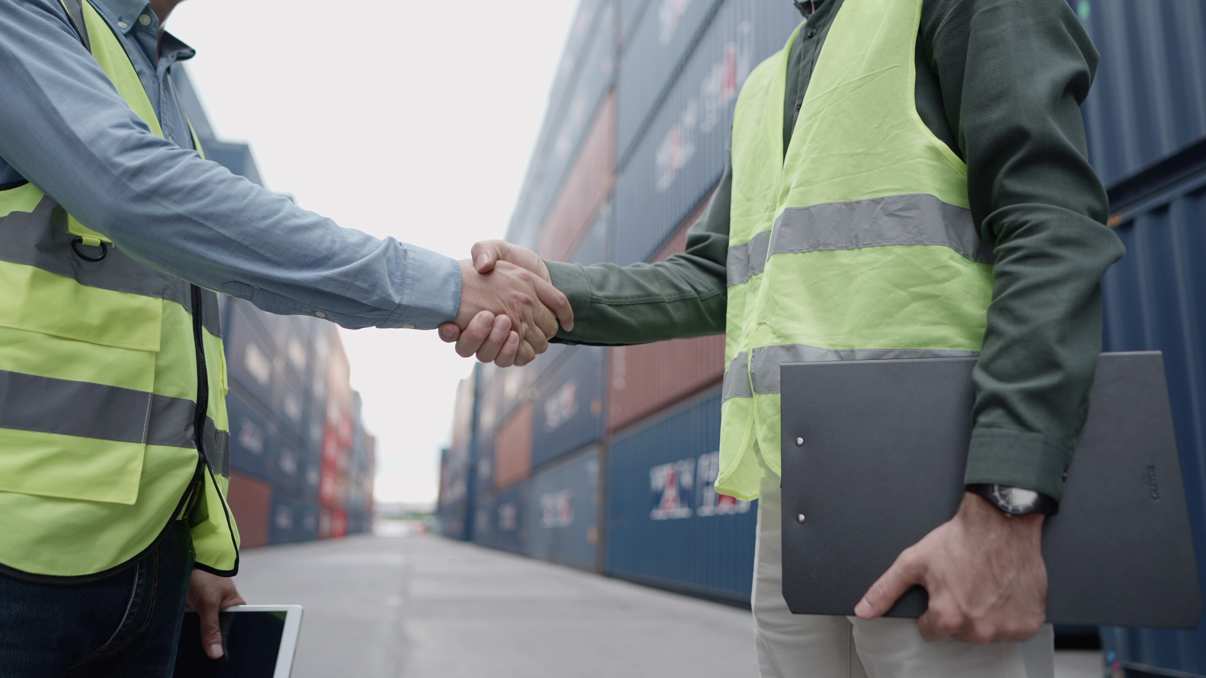 Partner in investor handshake after agreement to venture capital in business logistic or expand business for transportation. Executive or investor and logistics owner business or manager handshake greeting or congratulate when work done or deal to working is successful at container loading yard. Obscured face