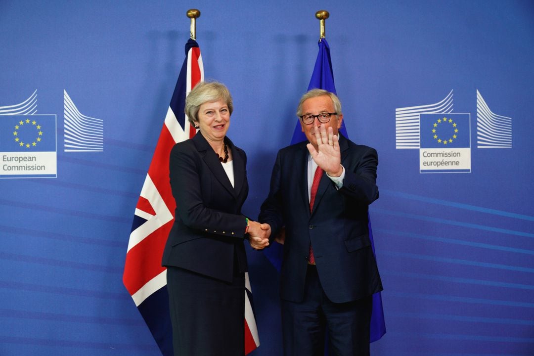 Jean-Claude Juncker estrecha la mano a Theresa May.