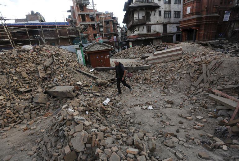 A tourist makes his way through the debris of a temple after an earthquake in Kathmandu, Nepal April 26, 2015, a day after Saturday&#039;s 7.9 magnitude earthquake which killed more than 2,400 people and devastated Kathmandu valley. REUTERS/Adnan Abidi