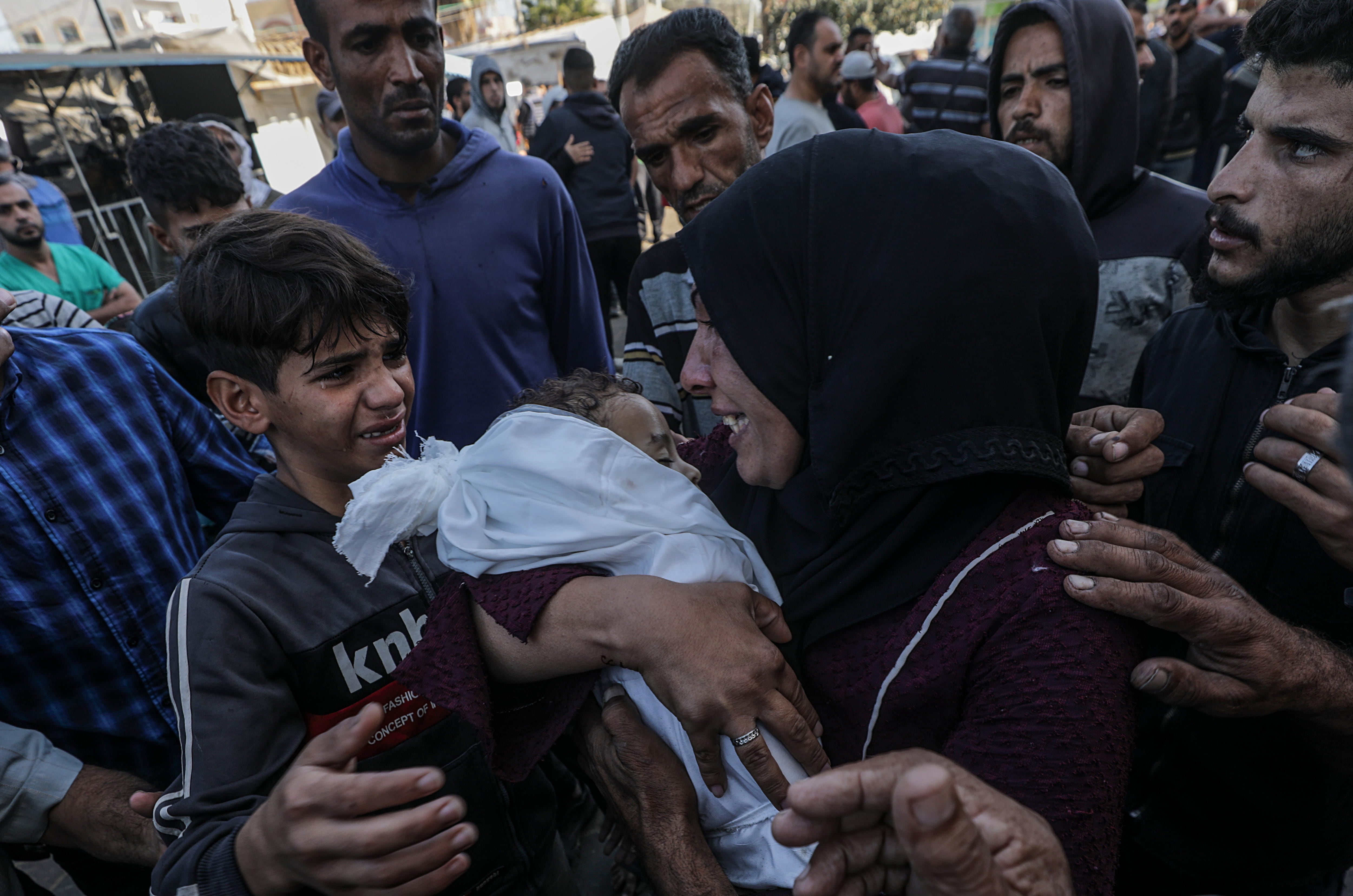 Una madre sostiene en brazos el cadáver de su hijo menor de edad tras un bombardeo israelí sobre la Franja de Gaza