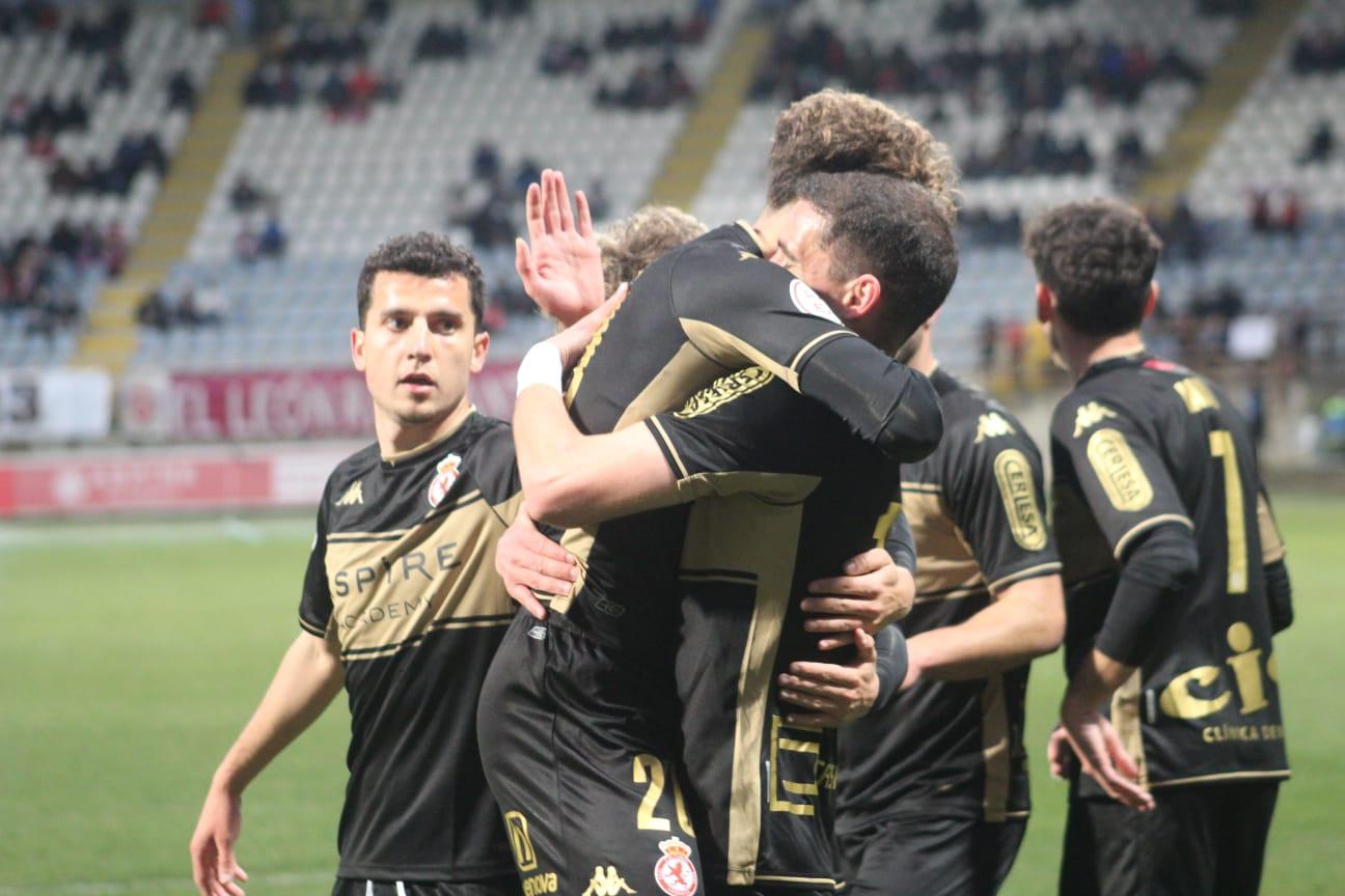 Buenacasa, abrazado tras el primer gol del partido