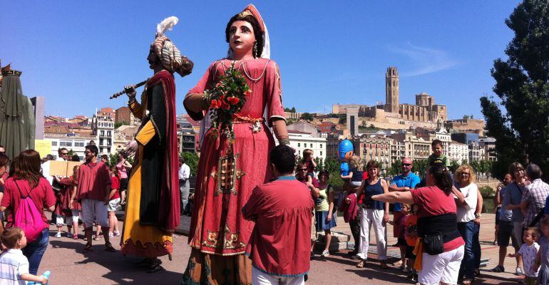 Una parella de gegants ballant a la passarel·la del riu