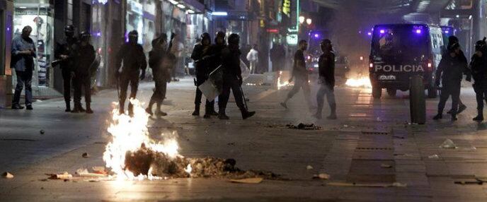 Policias antidisturbios controlan los accesos de la calle Preciados después de la concentración espontánea que ha tenido lugar este miércoles en apoyo a los mineros y contra los recortes anunciados por el Gobierno en la madrileña Puerta del Sol, donde se han registrado cargas policiales.