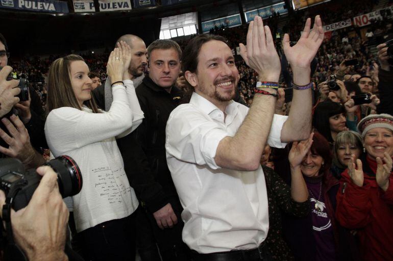 Podemos ('We can') Party secretary general Pablo Iglesias (R) applauds next to party member Angela Ballester (L) during a party meeting in Valencia January 25, 2015. REUTERS/Heino Kalis (SPAIN - Tags: POLITICS)