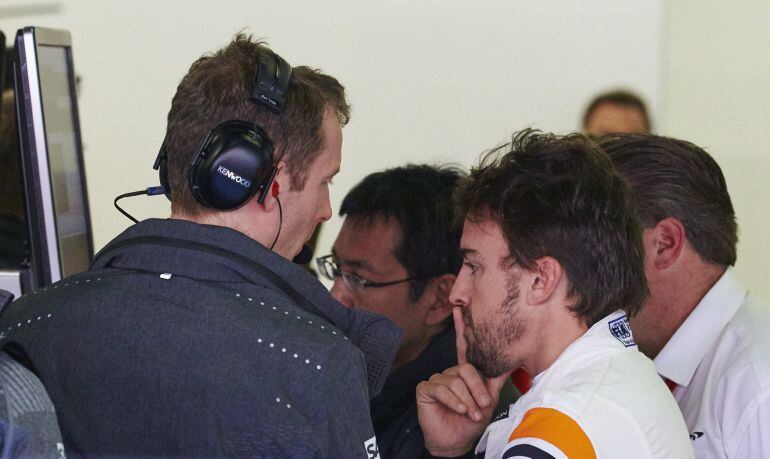 El piloto español de McLaren, Fernando Alonso, conversa con sus mecánicos en el box durante la primera sesión de entrenamientos libres en el circuito de Montmeló.