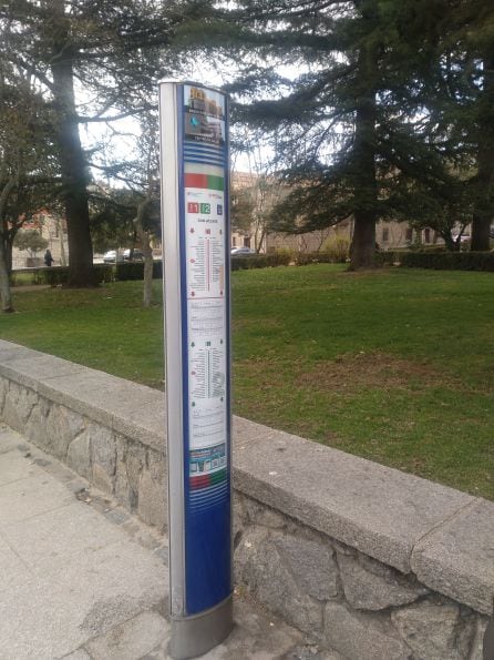 Parada de autobus con pictogramas en la parte superior que informan de la cercanía de la Basílica de San Vicente y de un centro de salud