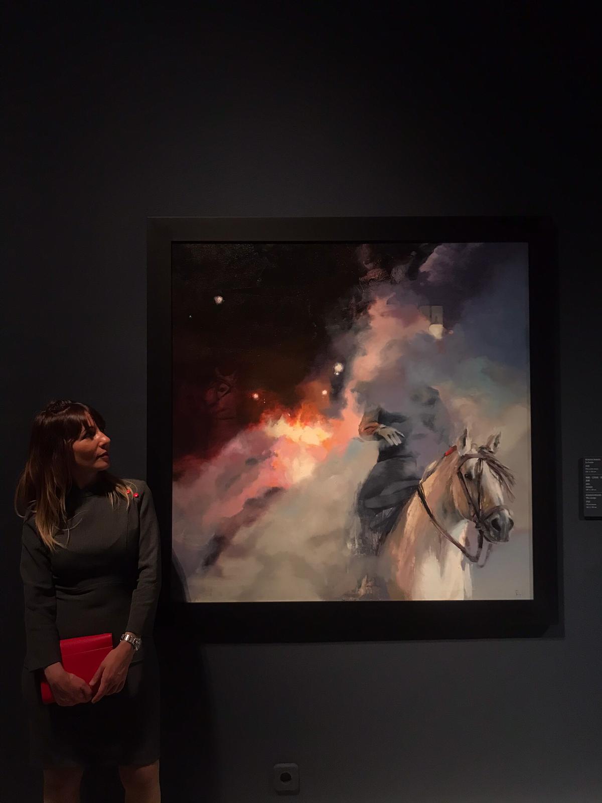 La pintora delante de su cuadro durante la inauguración