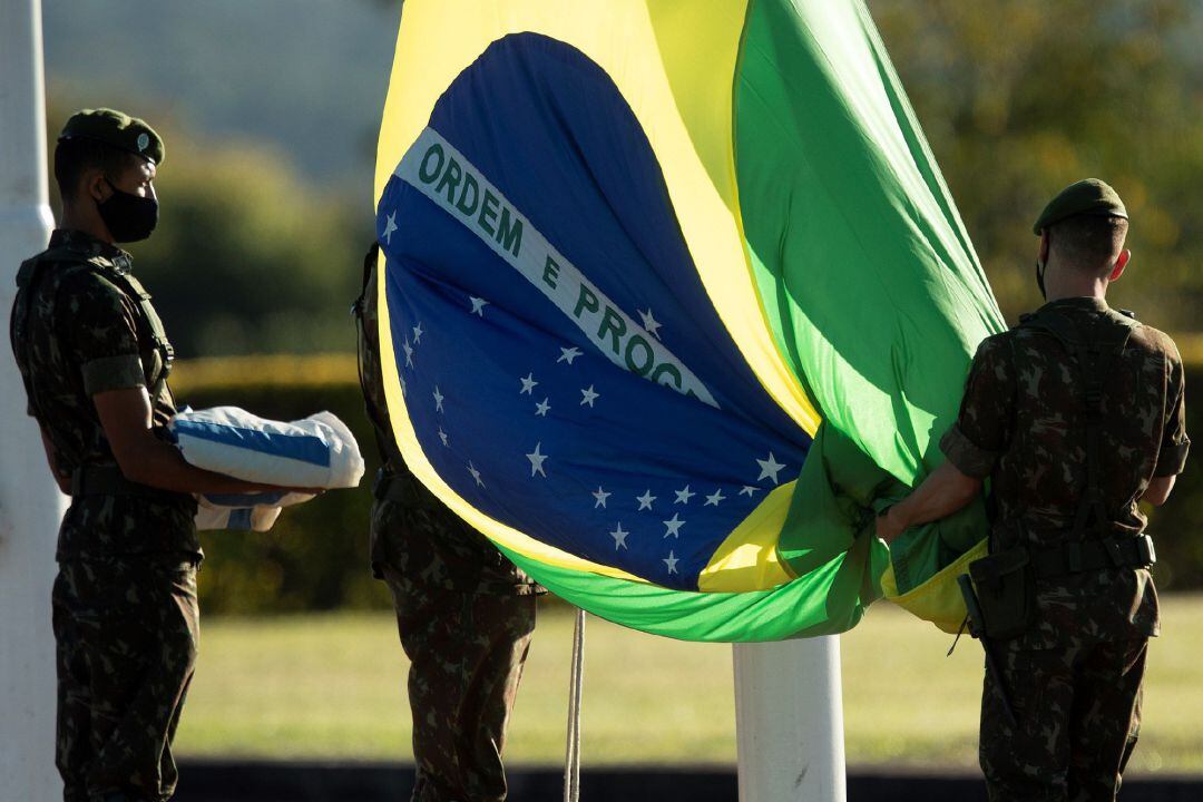 Soldados del Ejército brasileño izan la bandera nacional en el Palacio do Alvorada, sede de la presidencia, en Brasilia. 