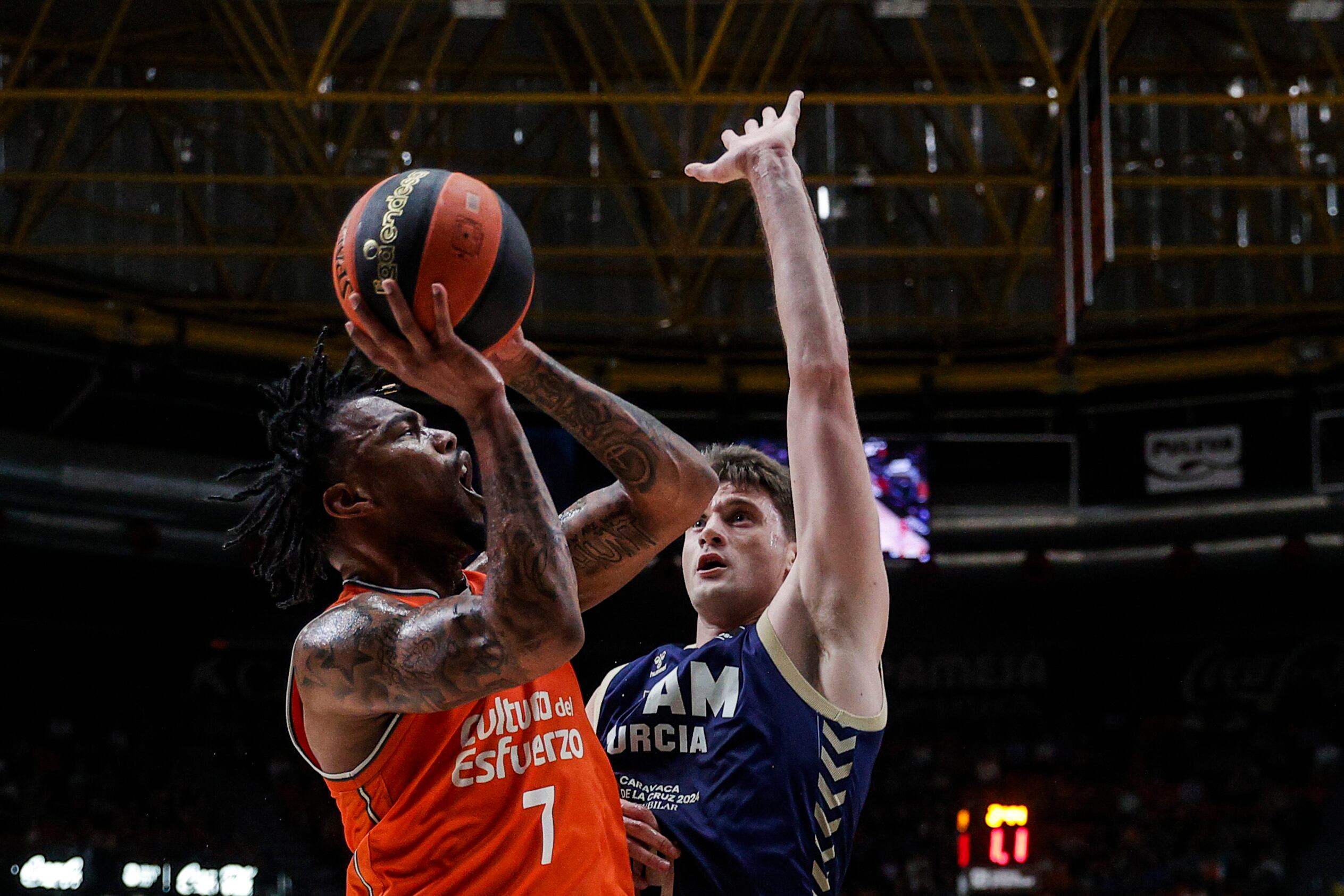 GRAFCVA9569. VALÈNCIA, 24/03/2024.- El base armenio de origen estadounidense del Valencia Basket, Chris Jones, trata de superar la defensa del ala pivot estadounidense del UCAM Murcia, Dustin Sleva, durante el partido correspondiente a la jornada 26ª de la Liga ACB jugado esa tarde en el pabellón de la Fuente de San Luis de València. EFE/Manuel Bruque