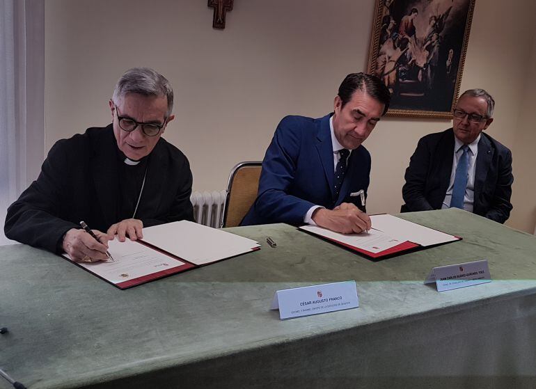 El consejero de Fomento, Juan Carlos Suárez-Quiñones - centro - firma con el Obispo de Segovia, César Franco el protocolo de cesión de viviendas en presencia del delegado de la Junta Javier López-Escobar