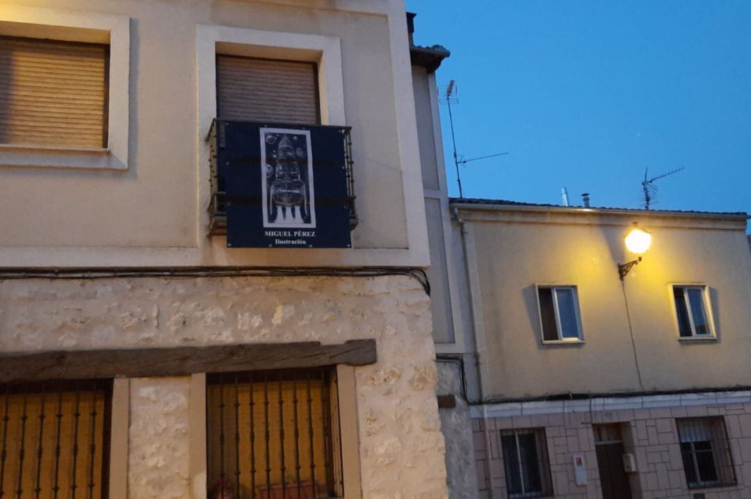 Lona en un balcón en la plaza de El Salvador que muestra una obra del artista local Miguel Pérez