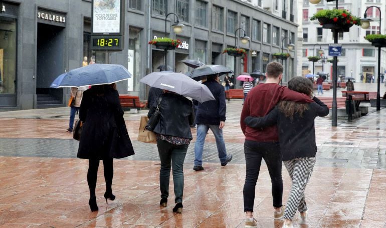 Lluvia en una calle comercial del centro de Oviedo.