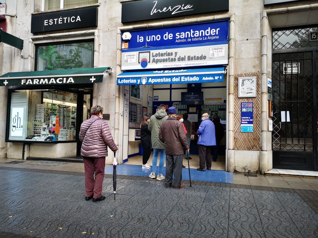 Clientes haciendo cola en una administración de lotería de Santander días previos al sorteo de Navidad.