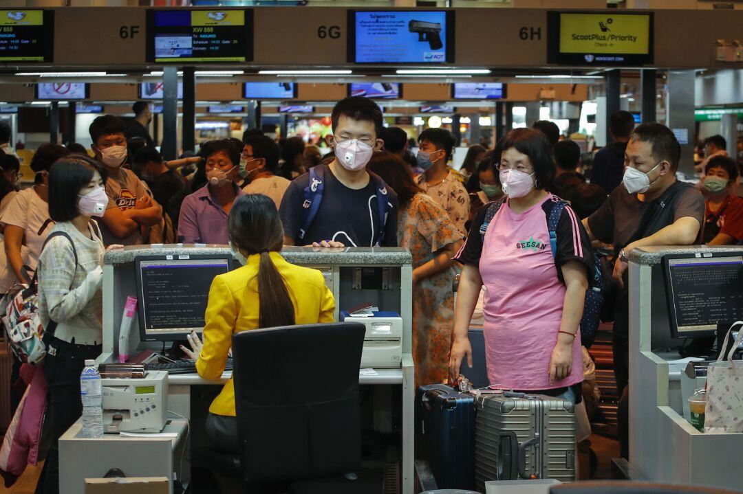 Turistas chinos con máscaras protectoras se registran para su vuelo a China en el aeropuerto Don Mueang en Bangkok