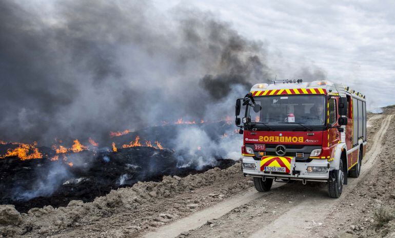  Un camión del cuerpo de bomberos pasa junto a los neumáticos que arden en Seseña (Toledo)