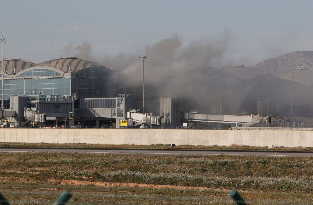 Vista general del incendio en una de las cubiertas de la terminal de embarque que ha obligado a evacuar y cerrar el tráfico aéreo en el aeropuerto de Alicante-Elche ha sido controlado por los bomberos sin que se tenga constancia de daños personales.