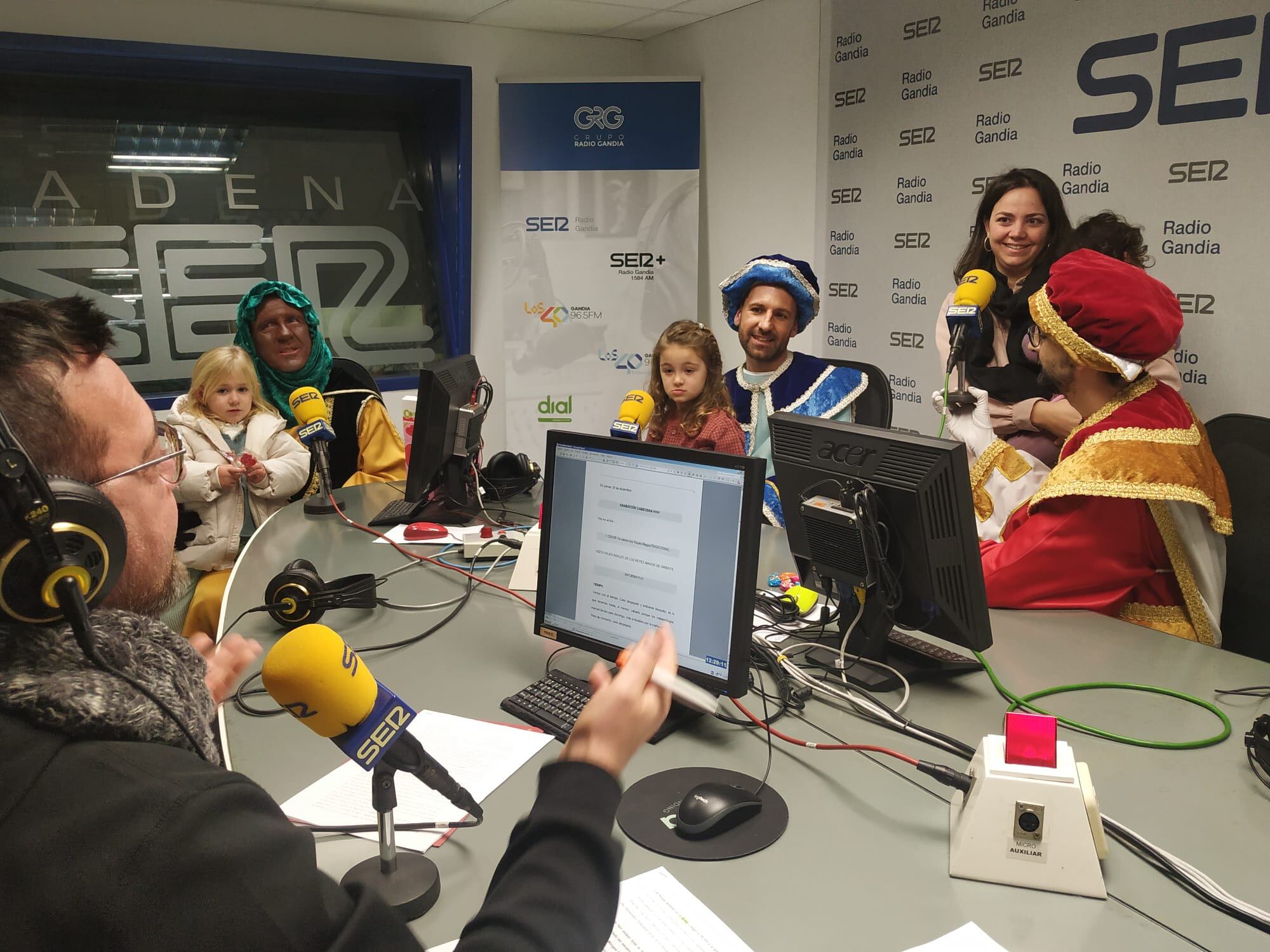 Niños y niñas saludan a los pajes reales durante la visita el pasado año.