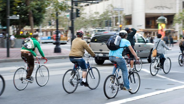 Un grupo de ciclistas circulan por una vía urbana.