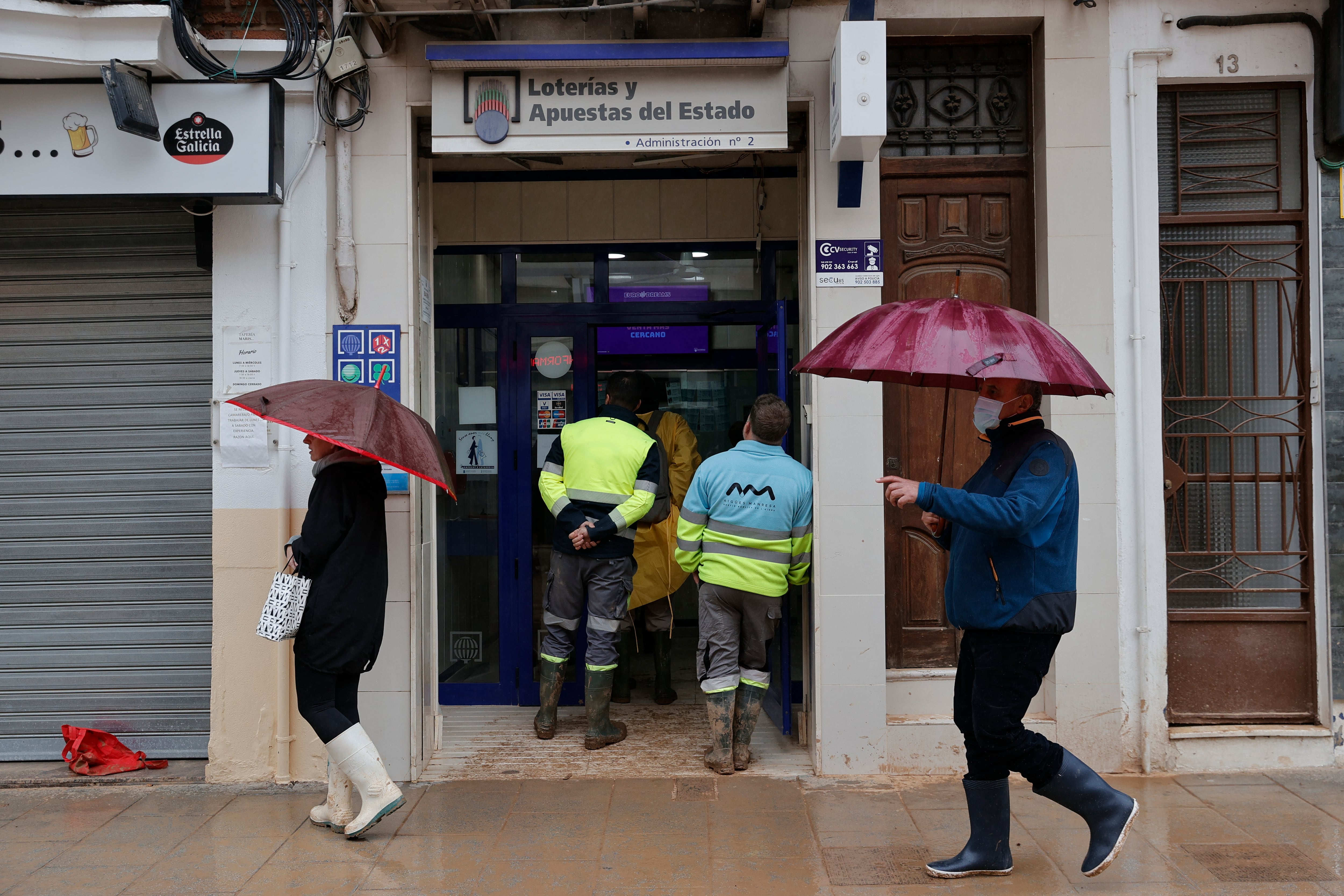 Varias personas hacen cola en una administración de Lotería en Catarroja, este miércoles. Docenas de municipios de Valencia asolados por la dana afrontan, en medio del inédito despliegue de emergencia y ayuda solidaria, la amenaza de una nueva dana que ha obligado a suspender las clases y condiciona aún más el ingente trabajo para atender las innumerables llamadas de ayuda que emergen desde cada barrio, polígono o escuela, en muchos casos todavía cubiertos de lodo.