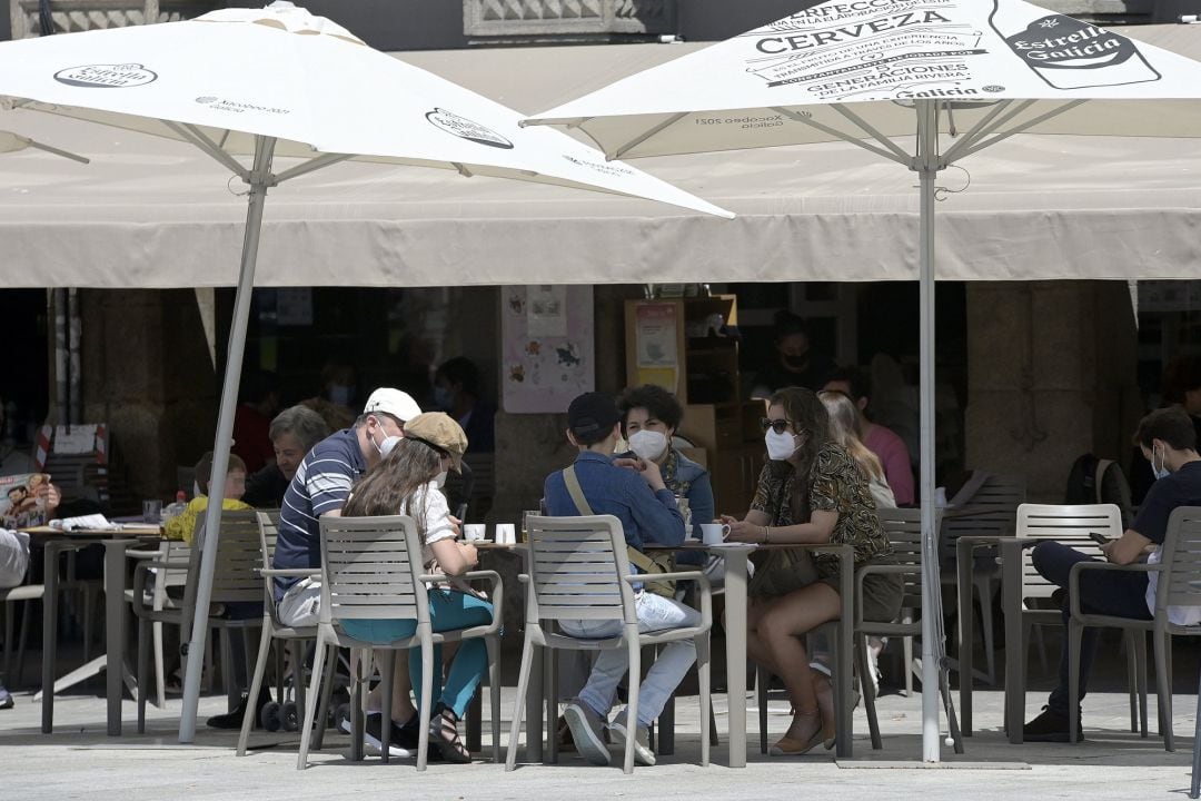 Varias personas en la terraza de un bar.