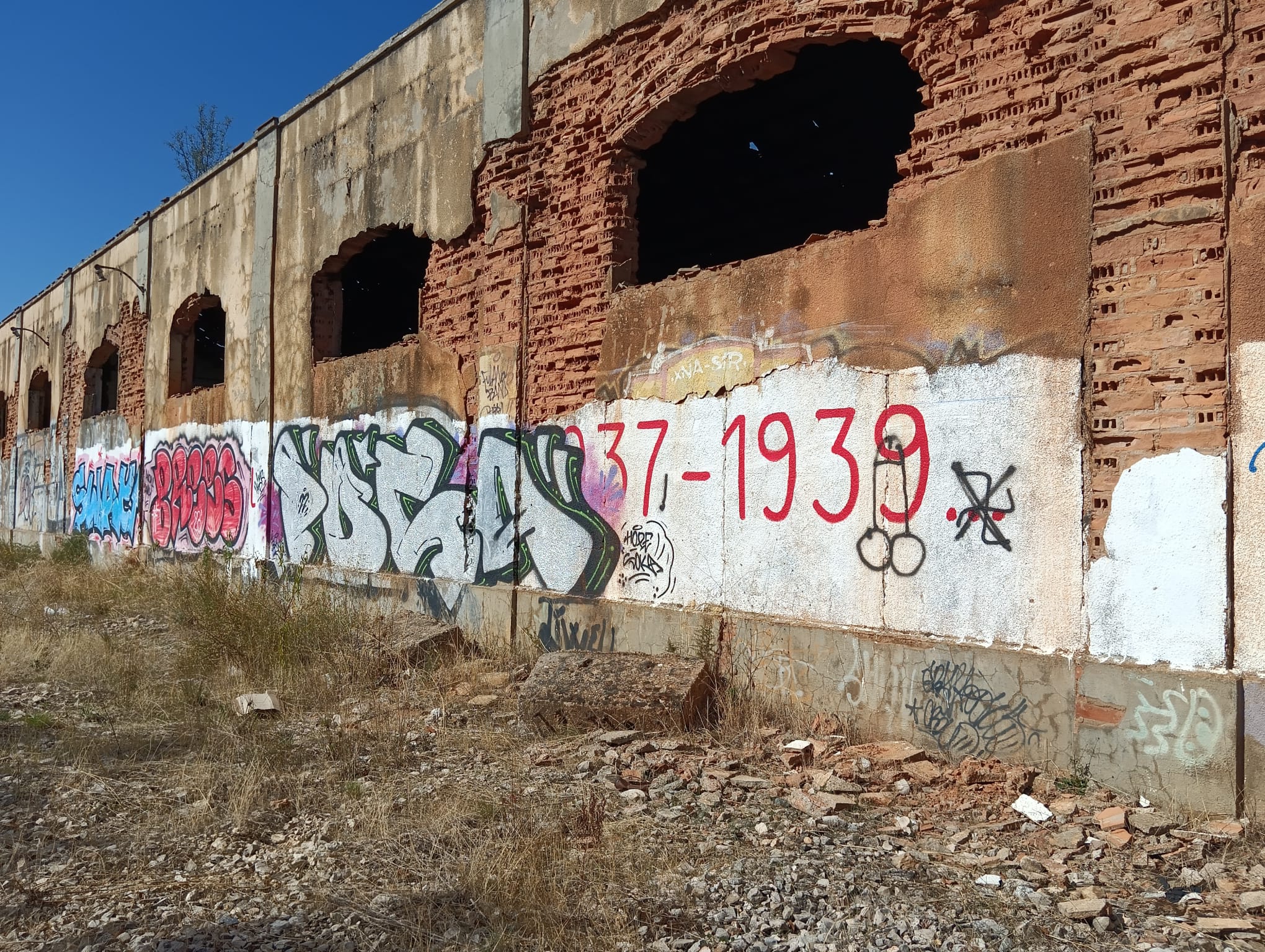 Aspecto actual del exterior de una de las naves, donde varios grafitis ocultan el rótulo que la identificaba como parte del campo de prisioneros