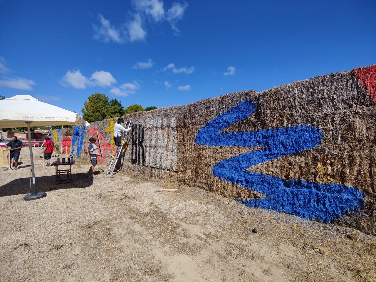 Momento de la decoración de la &quot;muralla&quot; de pacas