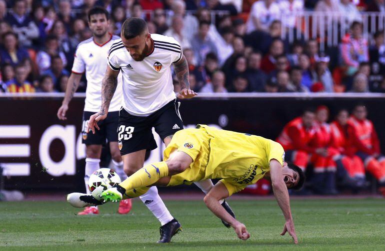 Valencia&#039;s Argentinian defender Nicolas Otamendi (L) tackles Villarreal&#039;s forward Gerard Moreno during the Spanish league football match Valencia CF vs Villarreal CF at the Mestalla stadium in Valencia on April 5, 2015.   AFP PHOTO/ JOSE JORDAN