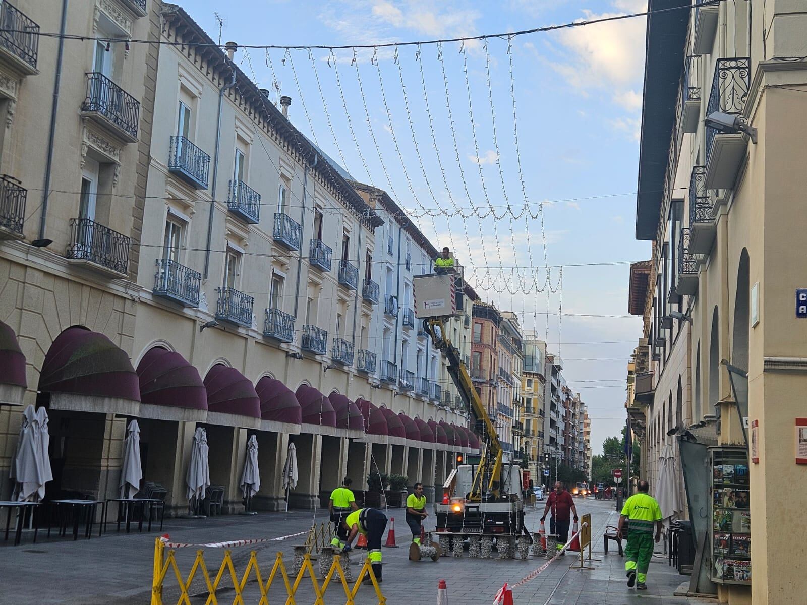 Las brigadas municipales, recogiendo la gran manta luminosa laurentina