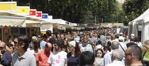 Cientos de personas se han acercado al parque de El Retiro de Madrid para pasear entre las diferentes casetas de la Feria del Libro