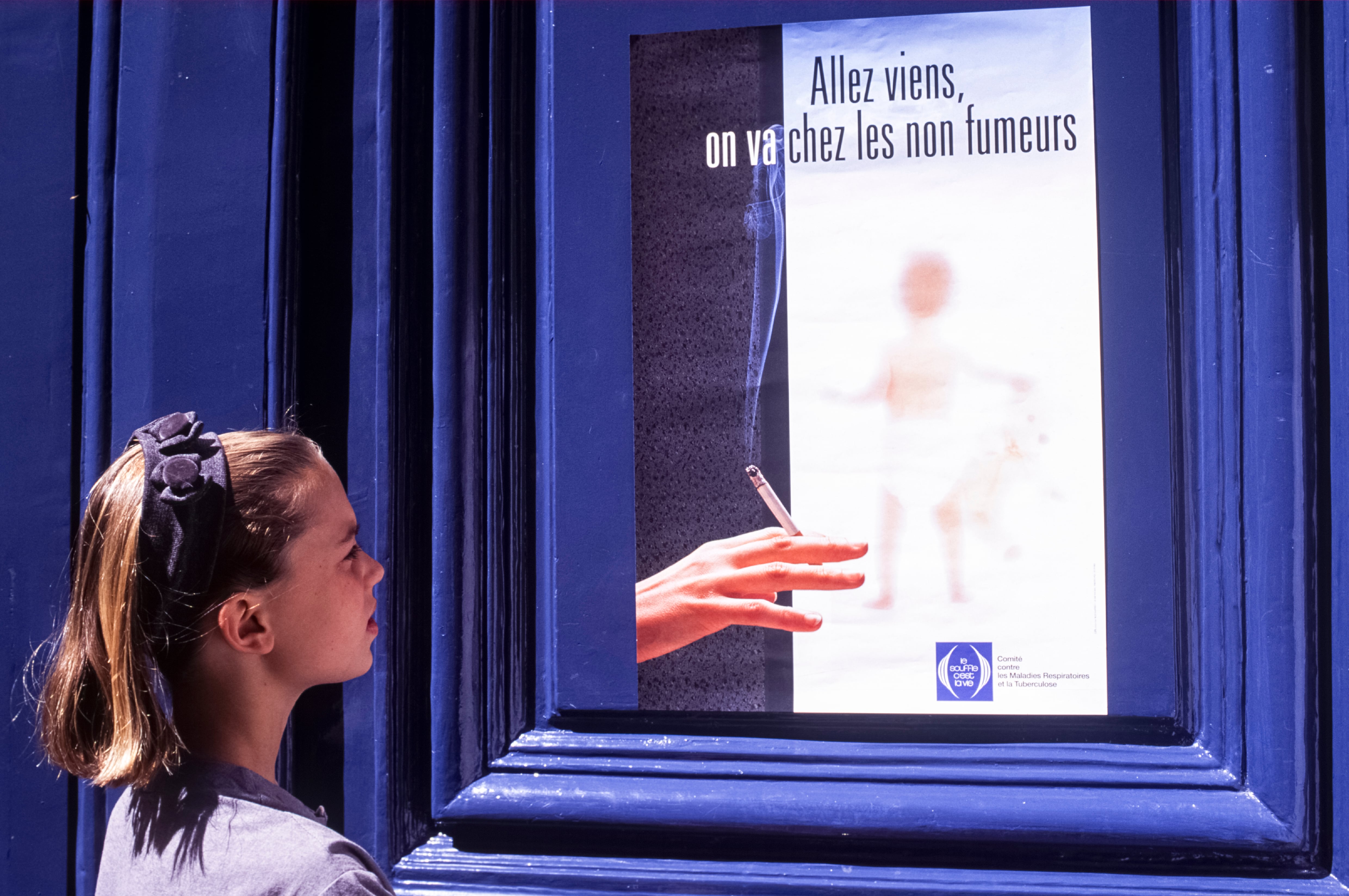 Una niña ante un cartel antitabaco en París