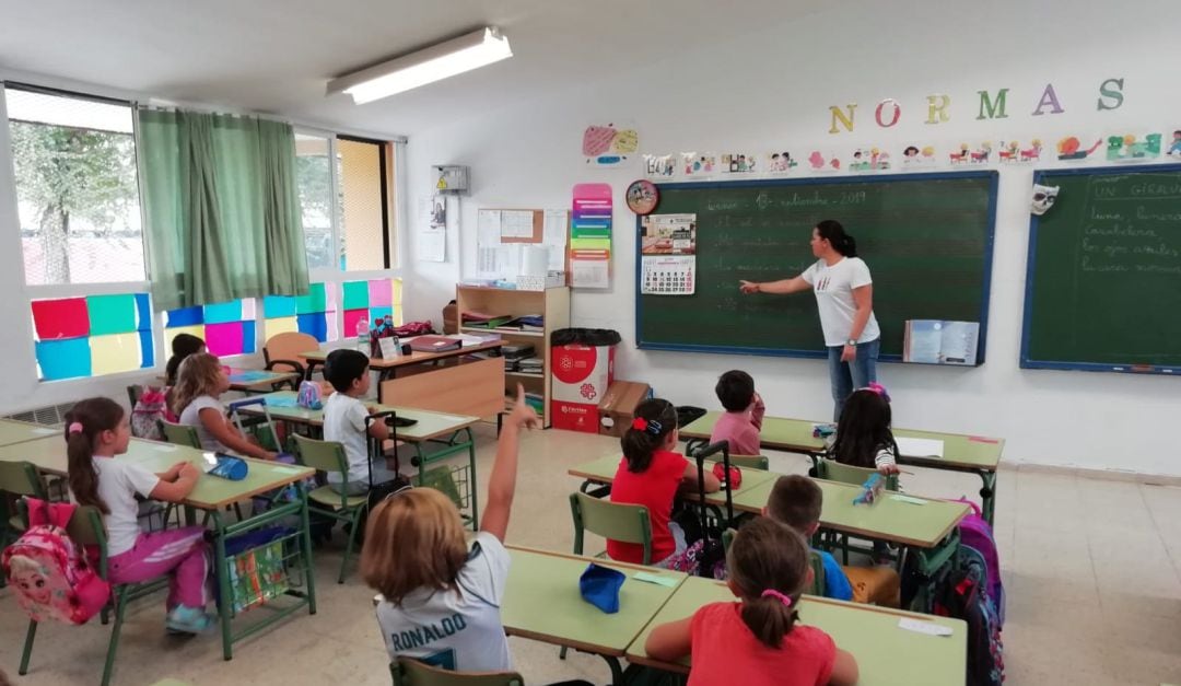 Una profesora da clases a alumnos de Primaria en un colegio.