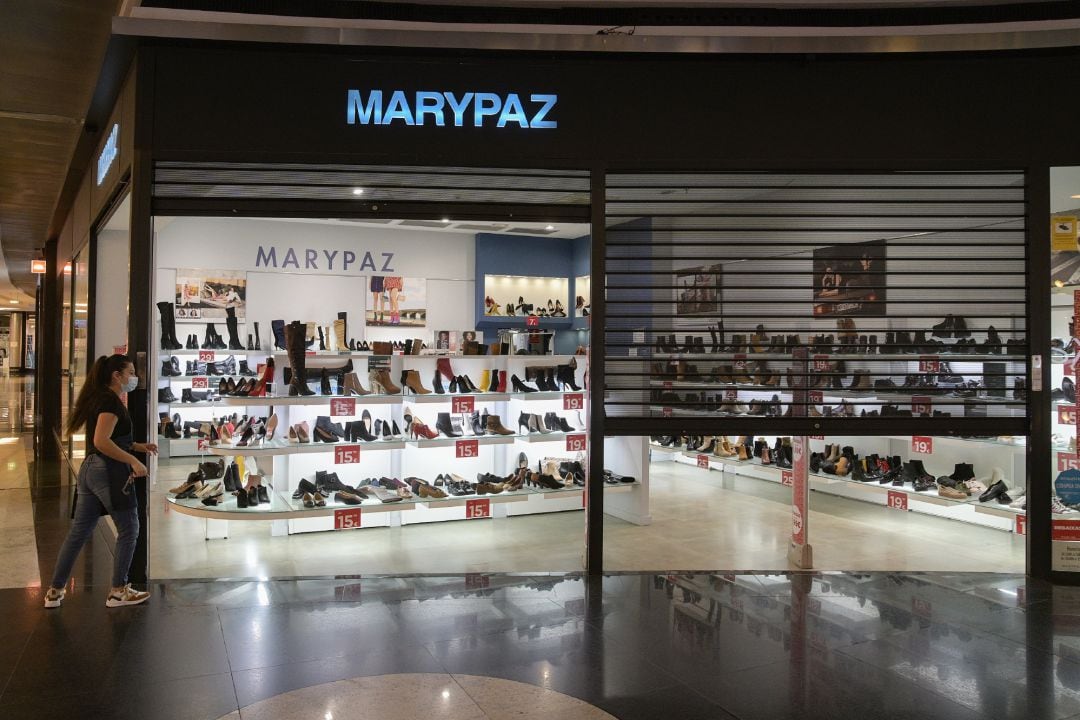 Una dependienta de la zapatería MARYPAZ cierra el establecimiento en un centro comercial