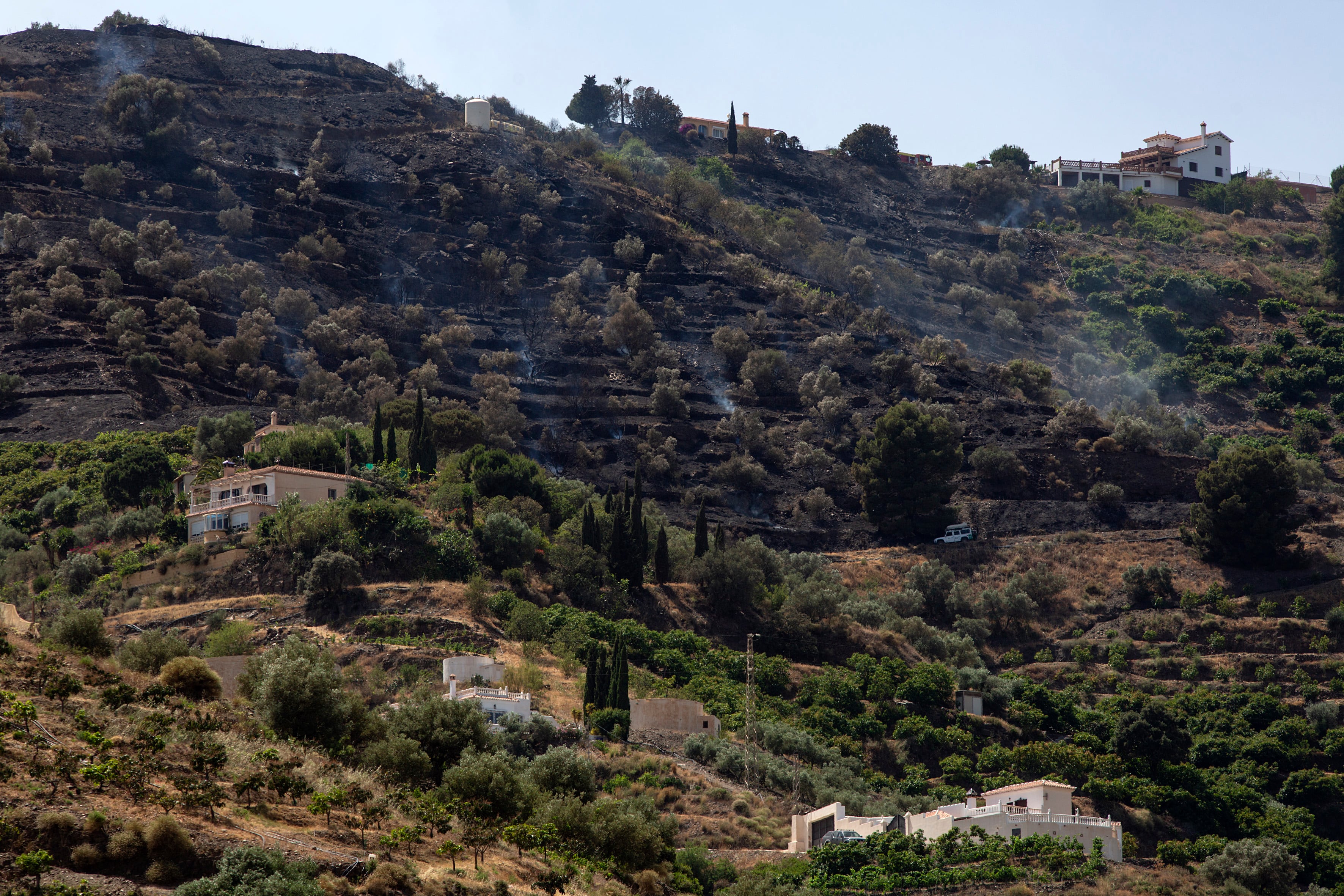 GRAF139. TORROX (MÁLAGA), 11/06/2022.- Vista de las zonas afectadas por el incendio originado en la localidad malagueña de Torrox. Para controlar el fuego se han desplazado dos helicópteros de transporte y extinción, dos aviones de carga en tierra, dos grupos de bomberos forestales, un técnico de operaciones y un agente de medioambiente. EFE/Daniel Pérez
