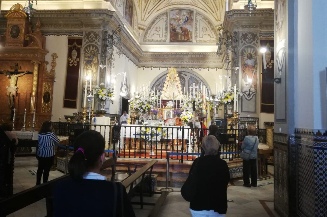 Fieles ante la Virgen del Rocío en la Iglesia de la Asunción de Almonte donde se han impuesto medidas de seguridad contra el Covid-19.