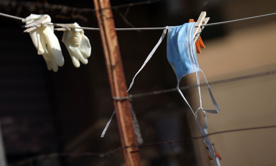 Guantes y una mascarillas colgados en una cuerda en Roma (Italia)