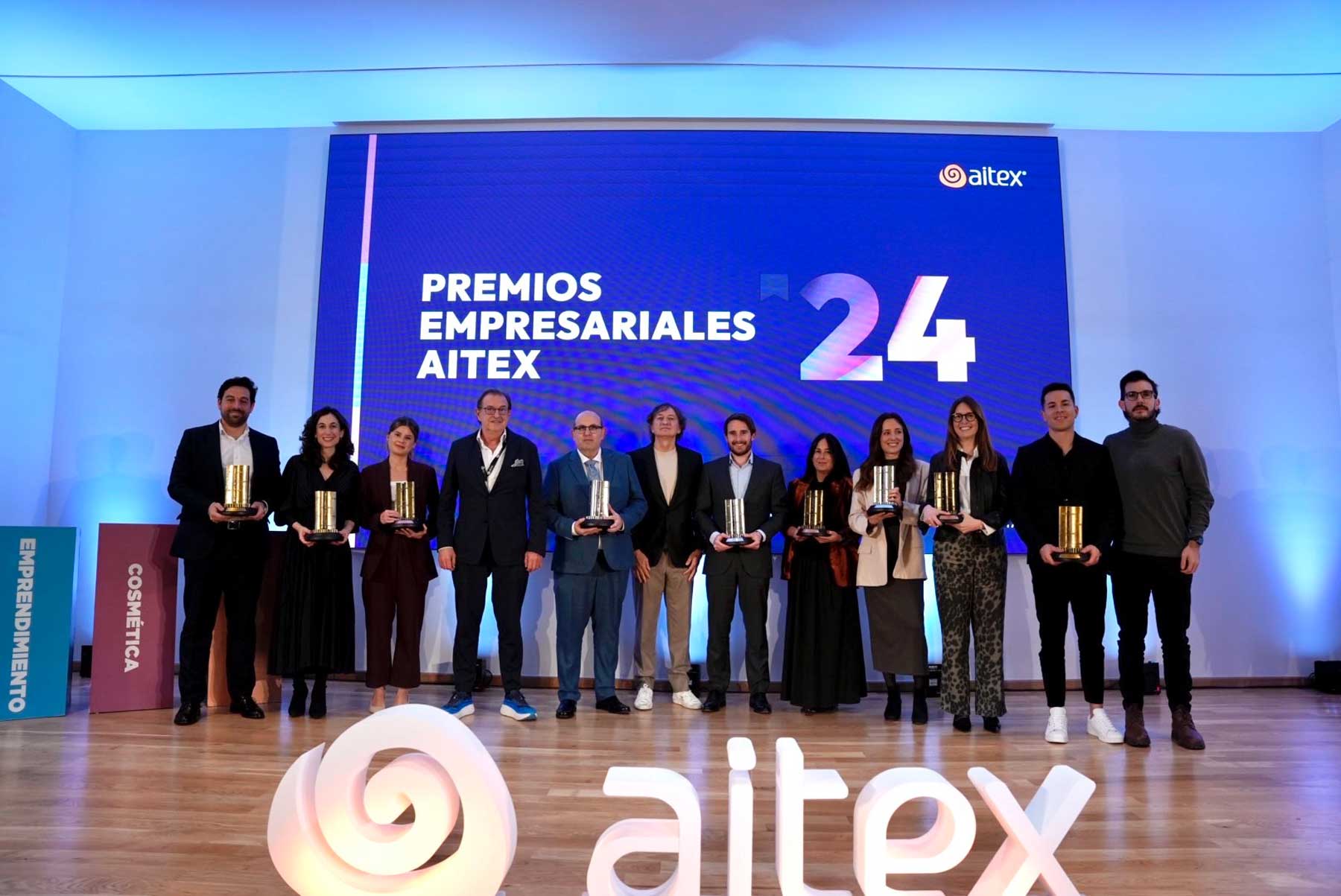 Imagen de familia de los nueve premiados junto a las autoridades en el escenario al finalizar el acto