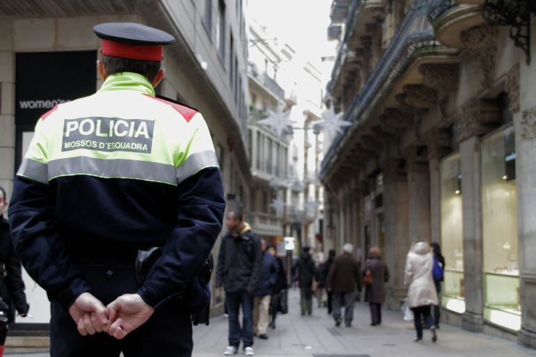 Un agent dels Mossos d'Esquadra en un carrer comercial en un operatiu per previndre robatoris