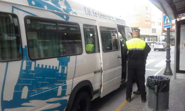 Agentes de la Policía Local, ayer subiendo a uno de los autobuses de la ciudad de La Línea.