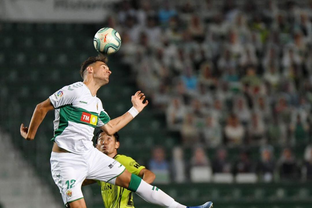 Dani Calvo despeja un balón ante un jugador.