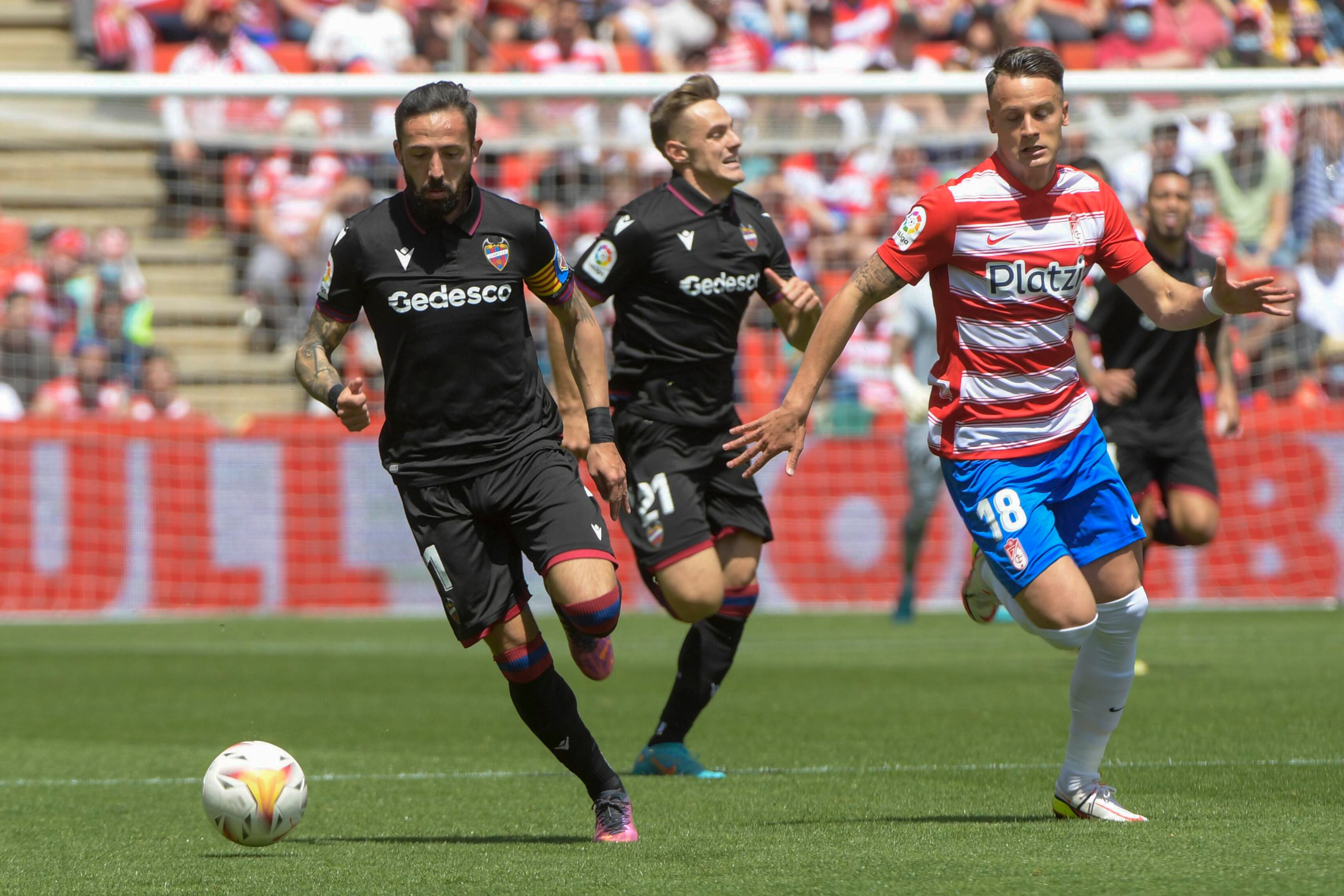 El lateral serbio del Granada Njegos Petrovic lucha por el balón con el delantero José Luis Morales, del Levante, durante su partido disputado en el Estadio Nuevo Los Cármenes de Granada. EFE/ Miguel Ángel Molina