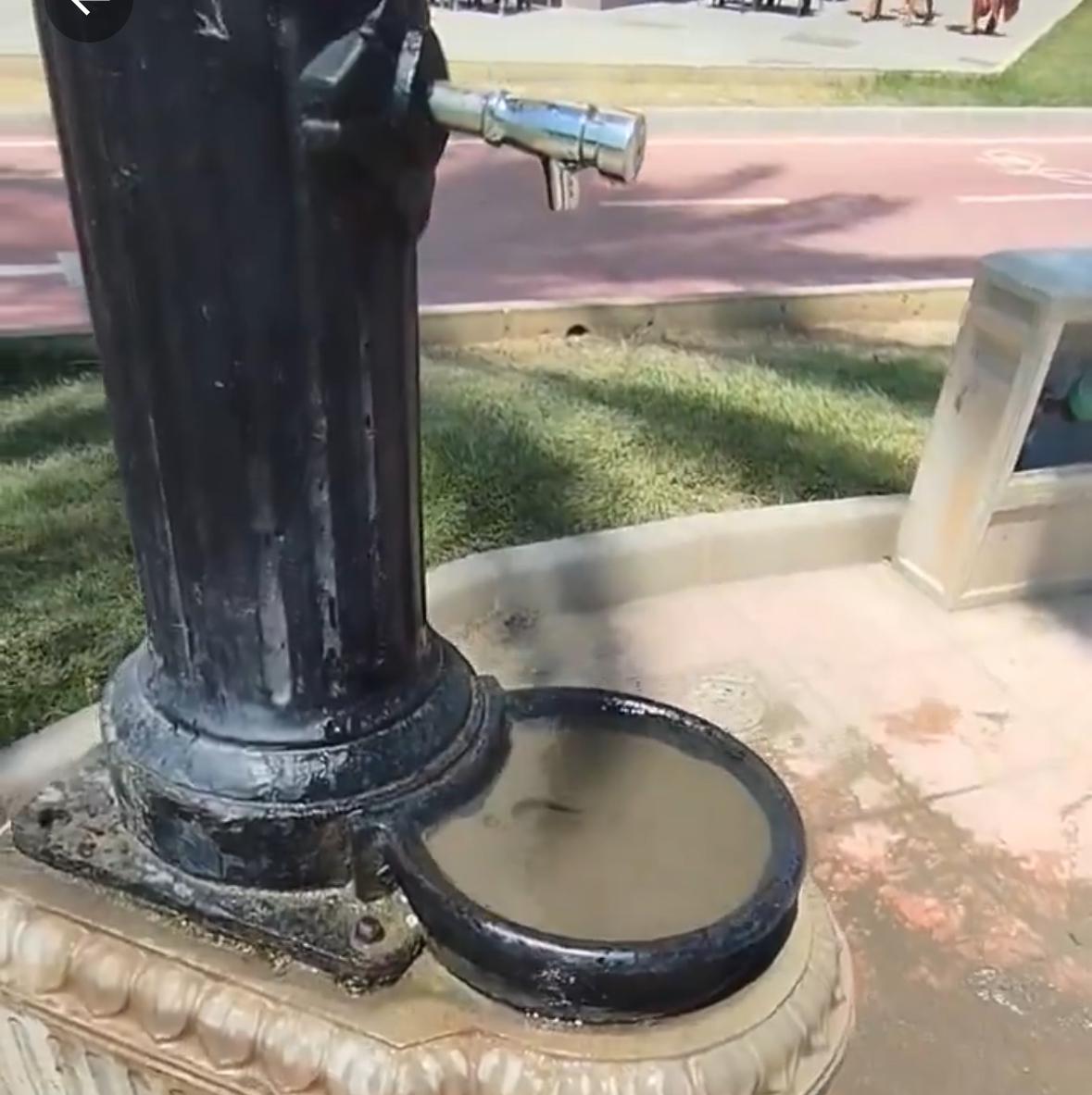 Uno de los bebederos de agua en Málaga con el sumidero lleno de arena de la playa