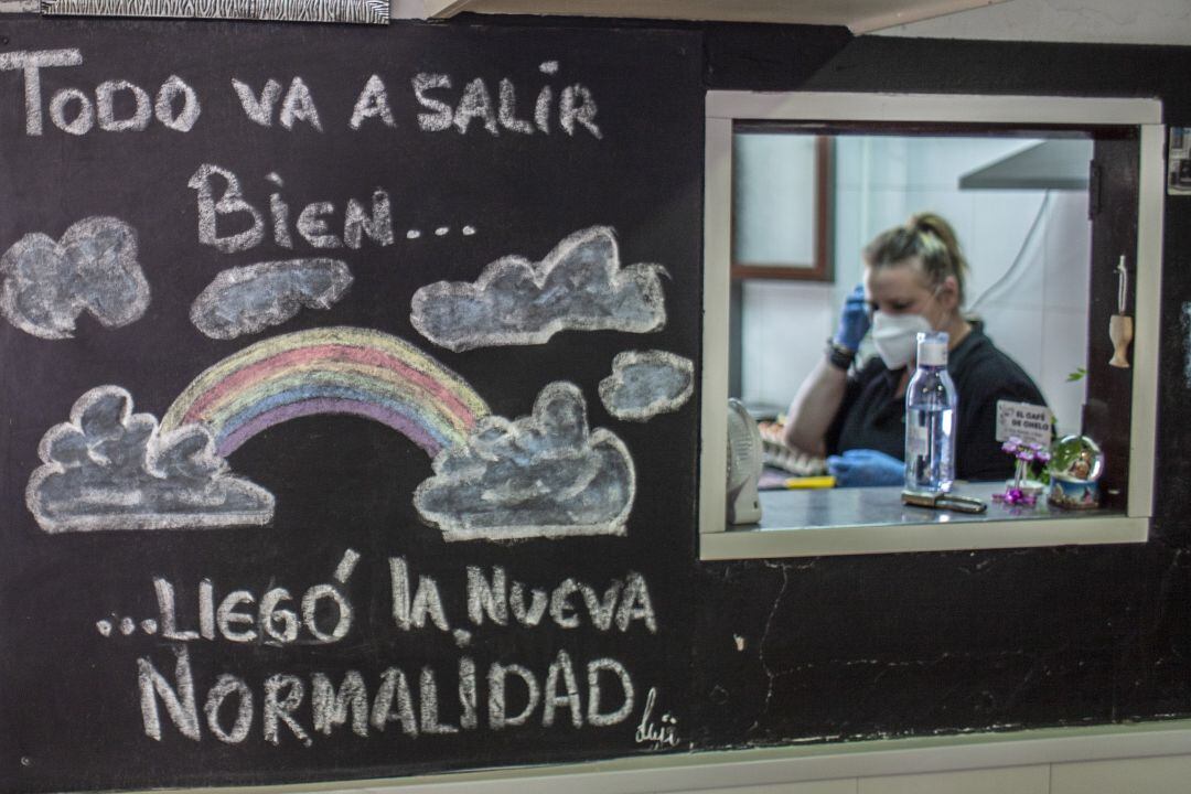 Una mujer trabajando en la cocina de un bar.