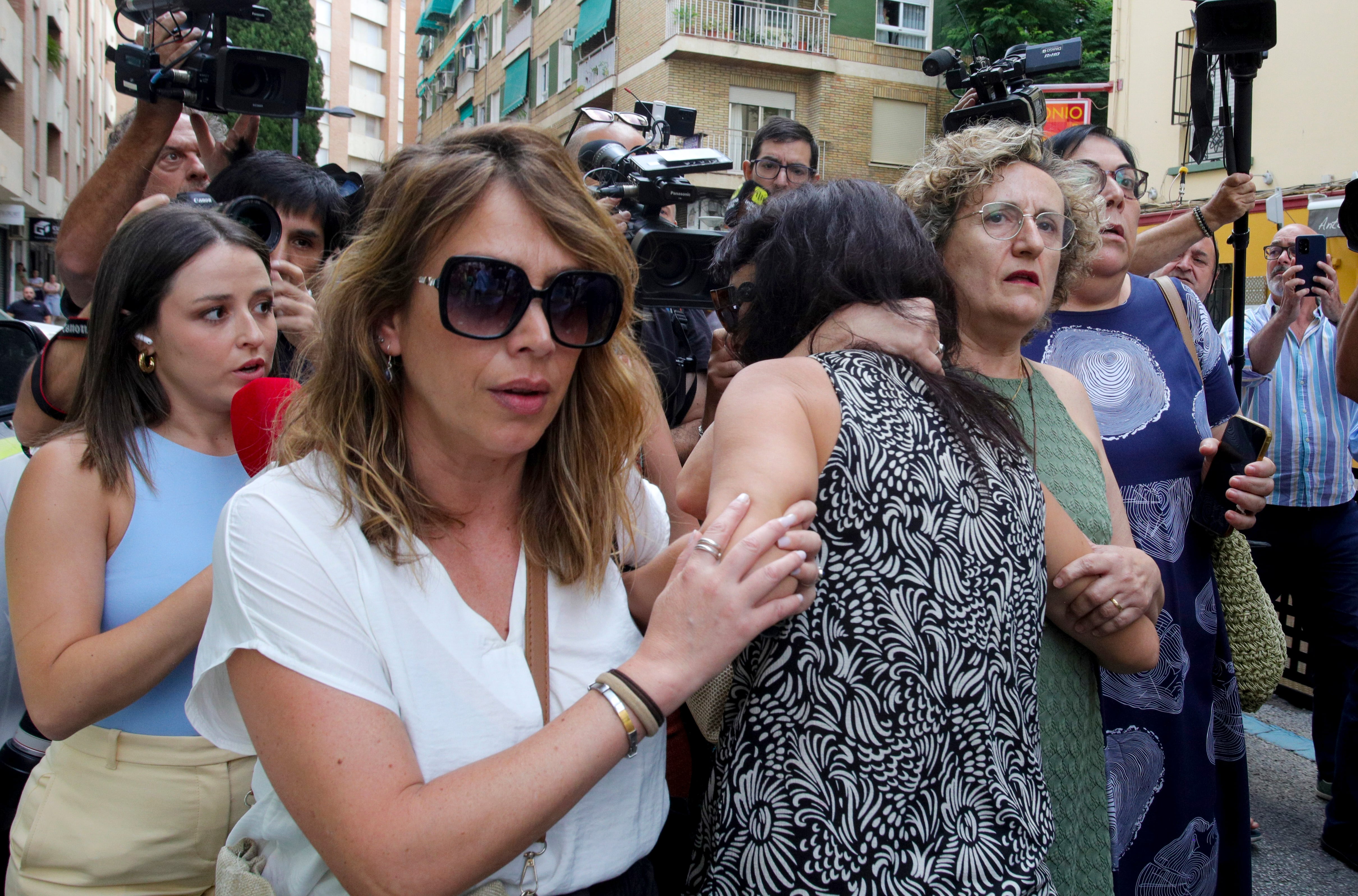 Juana Rivas (c) es consolada a su llegada al punto de encuentro fijado por orden judicial para que su hijo menor se reencuentre con su padre, el italiano Francesco Arcuri, que tiene la custodia, en Granada.