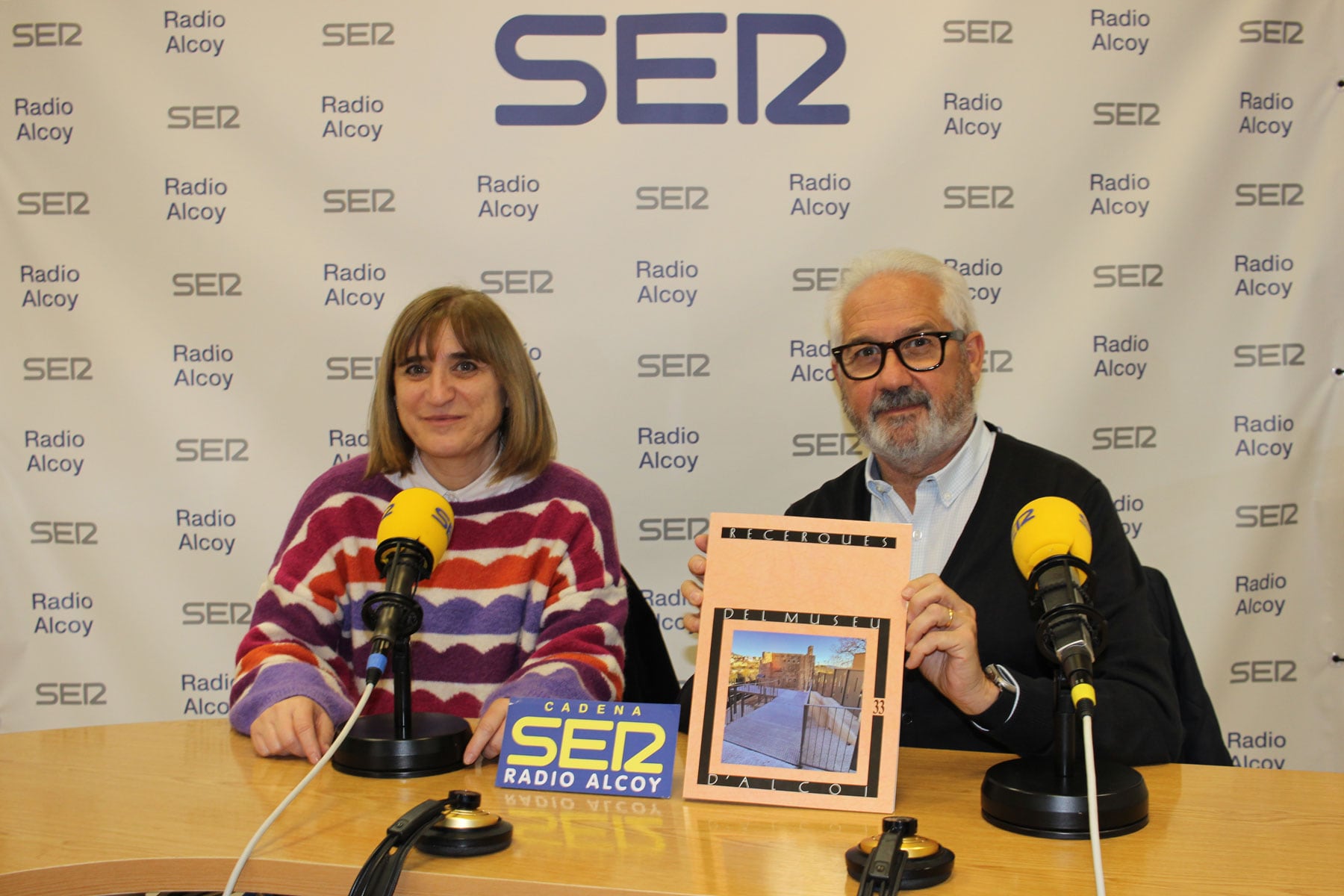 Palmira Torregrosa i Ignacio Trelis, en l&#039;estudi central de Radio Alcoy amb un exemplar de la revista &#039;Recerques&#039; recent presentada