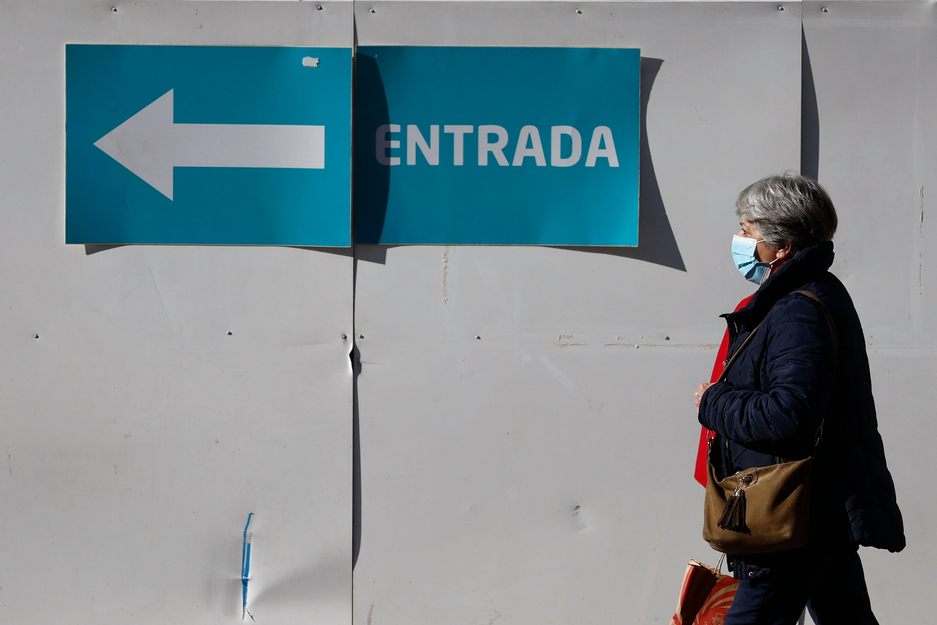 MADRID, 08/01/2024.- Una mujer con mascarilla camina en el entorno de un centro de salud en Madrid este lunes, día en el que el Ministerio de Sanidad ha pedido a las comunidades que implanten el uso obligatorio de la mascarilla en centros sanitarios y sociosanitarios, una medida que se aplicaría de forma transitoria mientras dure el pico epidémico de la gripe y otros virus respiratorios, y que ya han decretado Cataluña, la Comunidad Valencia y Murcia. EFE/ Rodrigo Jiménez
