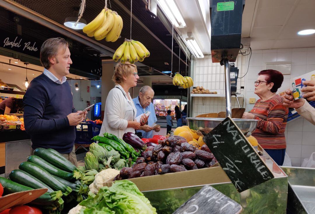 La candidata al Senado, Llum Quiñonero, y el portavoz municipal de Compromís, Natxo Bellido, visitando los puestos del Mercado