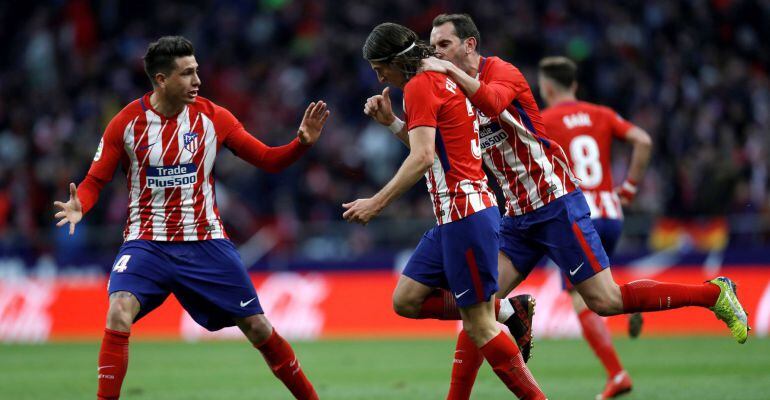 Filipe Luis celebra junto a Giménez y Godín su gol ante la Real Sociedad