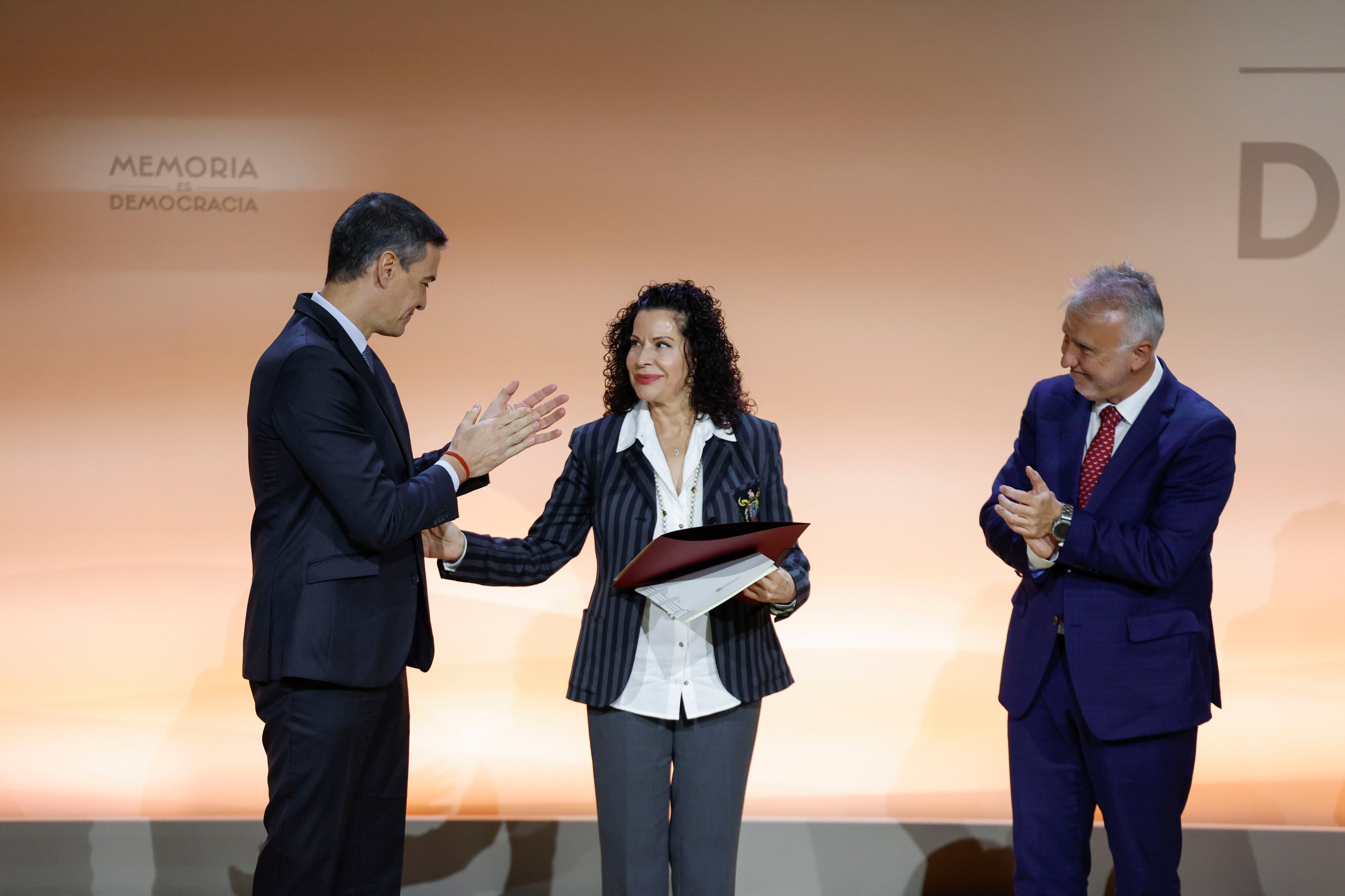 MADRID, 10/12/2024.- El presidente del Gobierno, Pedro Sánchez (i), y el ministro de Política Territorial y Memoria Democrática, Ángel Víctor Torres (d), entregan una distinción a nombre de Miguel Hernández, que recoge una de sus familiares, durante el acto institucional del Día de Recuerdo y Homenaje a todas las víctimas del golpe militar, la Guerra y la Dictadura este martes en el Auditorio Nacional en Madrid. EFE/ Javier Lizón
