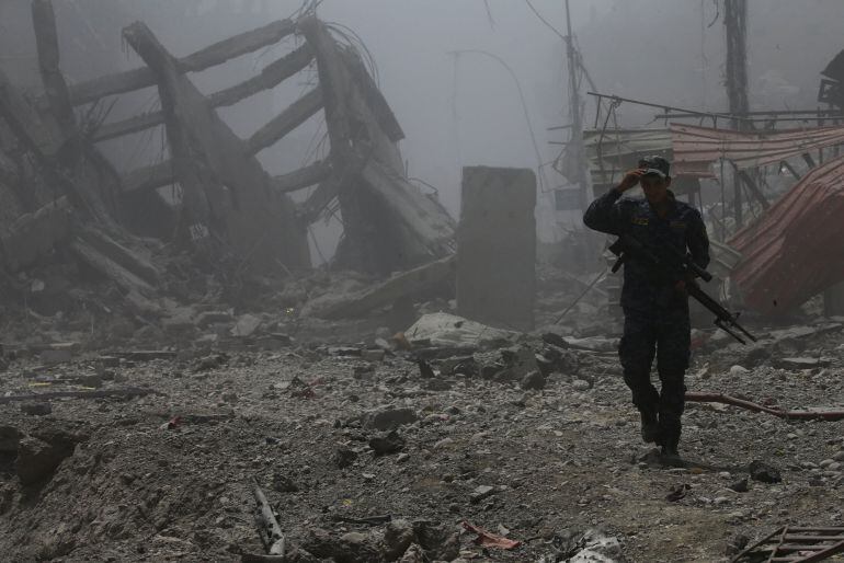 Un policía federal iraní camina entre los edificios destruidos en la vieja ciudad de Monsul. 