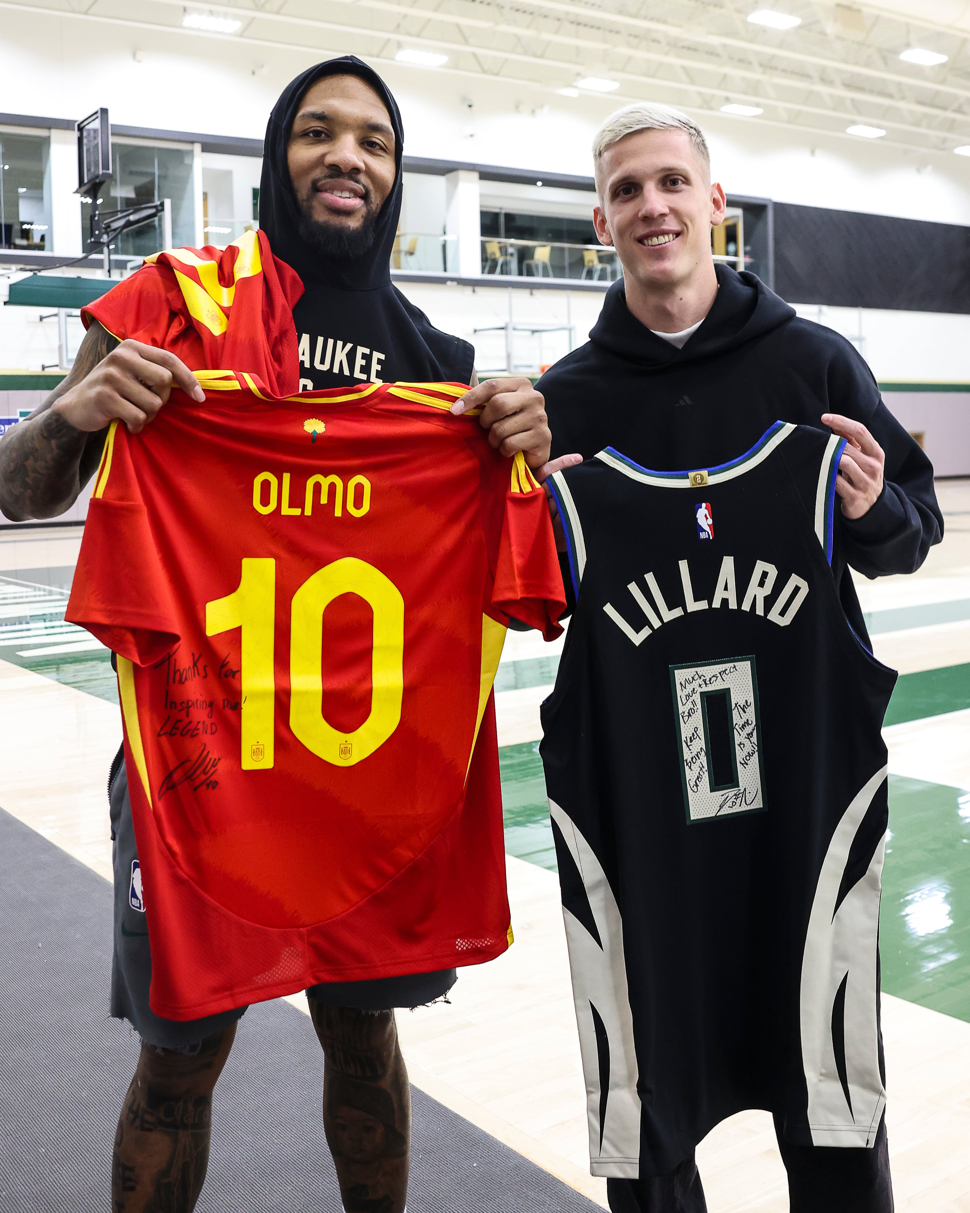 El futbolista español del Barcelona Dani Olmo  y el jugador de baloncesto de los Milwaukee Bucks Damian Lillard se intercambian sus camisetas